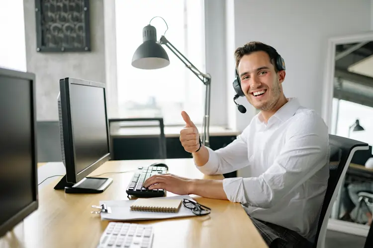 Operatore di call center sorridente dopo aver risolto il problema di un cliente insoddisfatto | QuBox