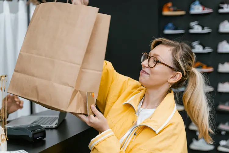 Donna acquista nel suo negozio di scarpe preferite, la brand identity la rassicura della bontà della scelta | QuBox