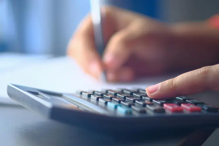 Calcolatrice, foglio di carta e penna per calcolare il brand value alla vecchia maniera | QuBox