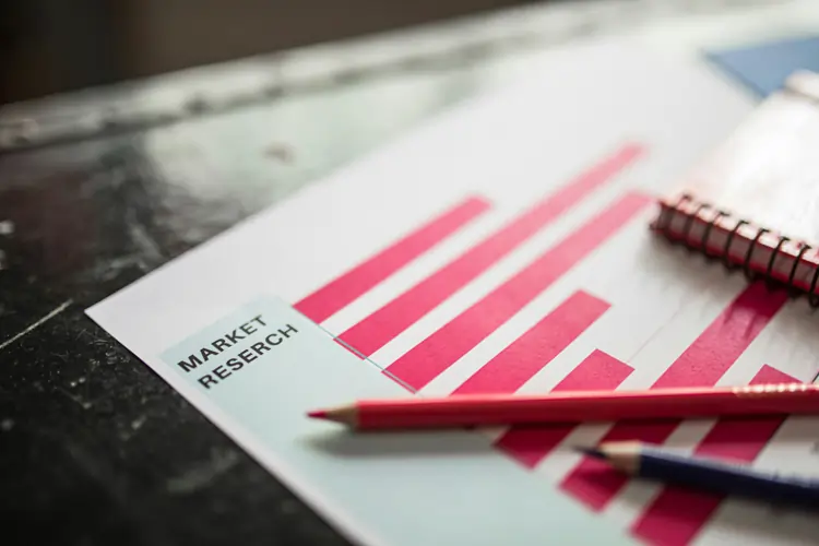 Fogli di carta sulla scrivania con dati e statistiche necessari per la misurazione nel tempo del brand value | QuBox