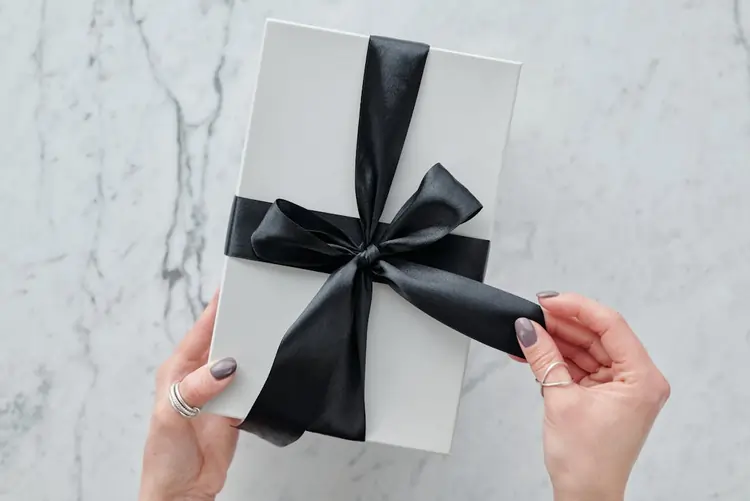 Elgante regalo aziendale ancora da scartare, con scatola bianca e nastro nero | QuBox